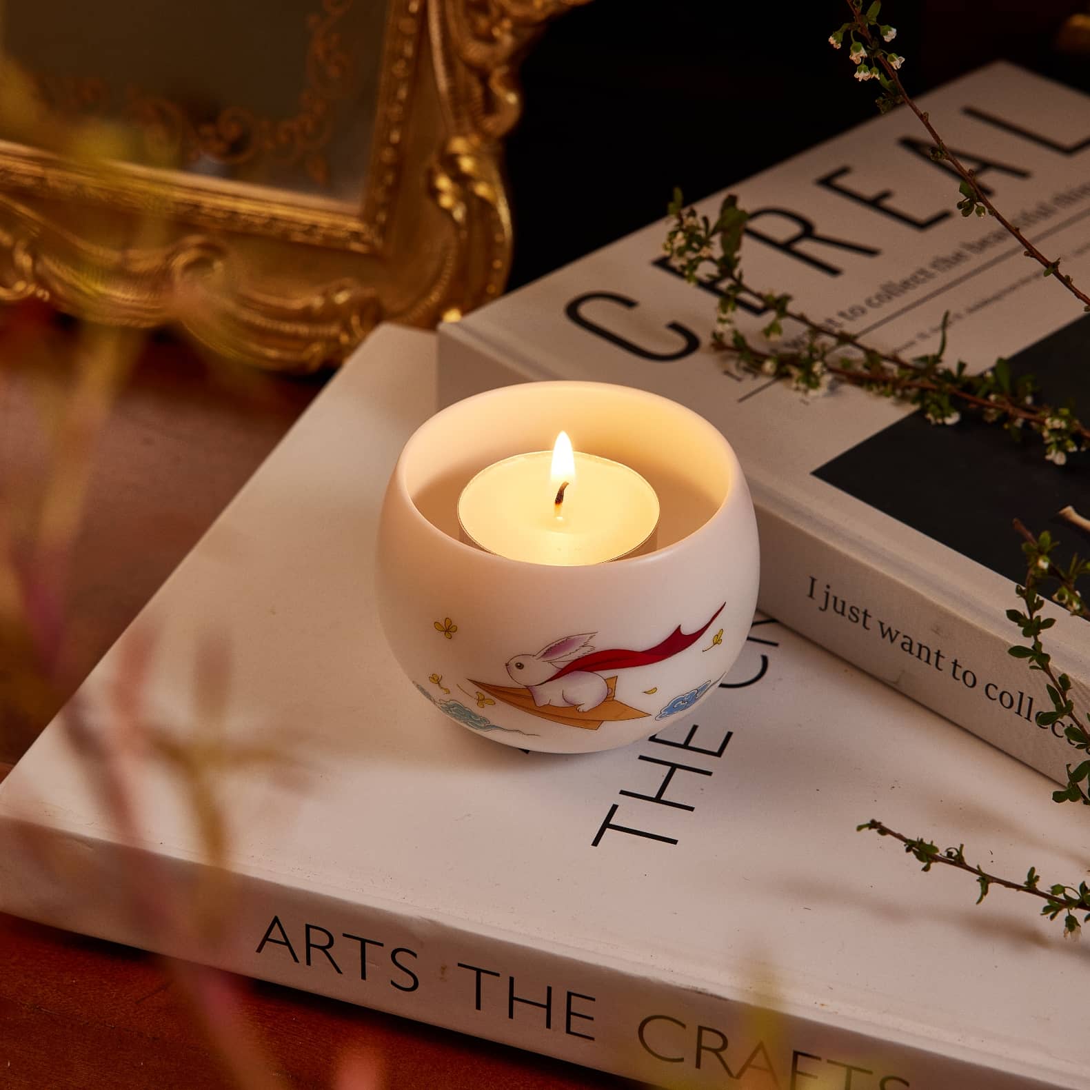 A tealight candle sand in a tealight candle holder which pattern is a rabbit stand on a paper plane.